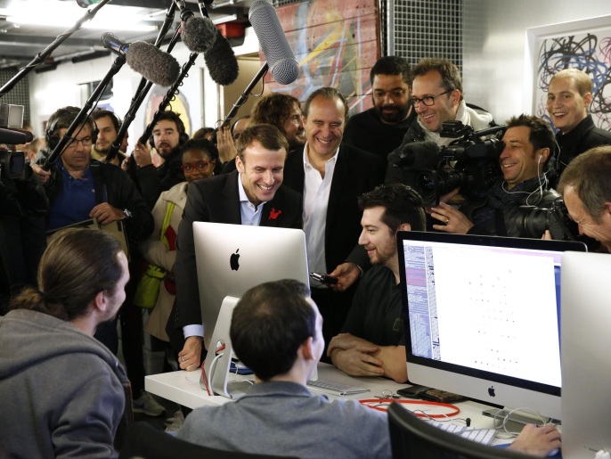 e21fe764-de69-44a8-ba8c-a903d575454e Journalists surround Xavier Niel (C), founder of French broadband Internet provider Iliad, French Economy Minister Emmanuel Macron (L) and Kwame Yamgnane (R) visit the 42 school campus in Paris, France, October 27, 2015. The French school 42, a private French computer programming school, was created and funded by Xavier Niel. REUTERS/Benoit Tessier