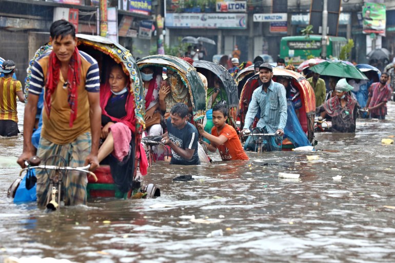 shutterstock_1780770011-1702462500 Dhaka, Bangladesh - July 21, 2020: Vehicles try to drive through a flooded street in Dhaka. Encroachment of canals ...