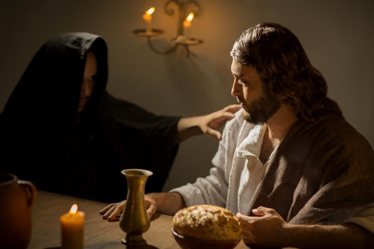 shutterstock_614320223-1705053490 The devil trying to make Jesus Christ fall into temptation during the last supper with his apostles