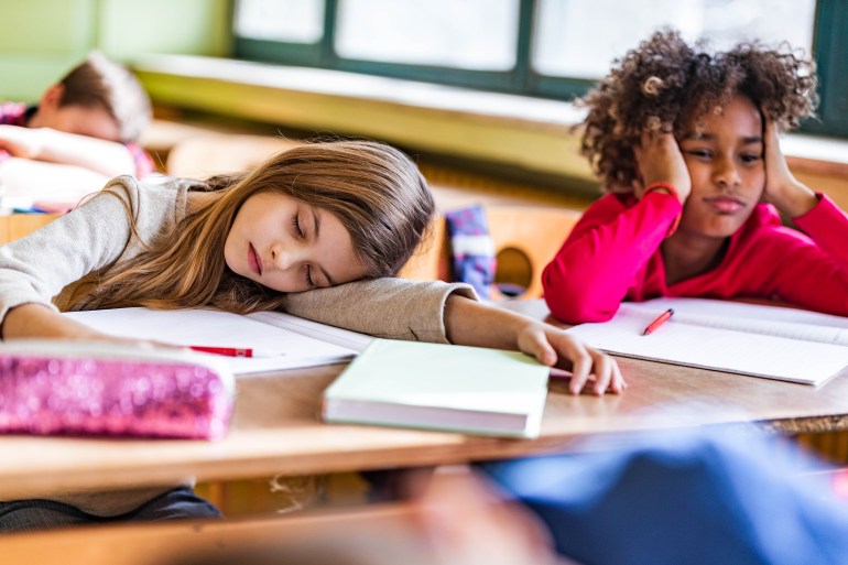 gettyimages-1386825389-1706896650 Tired schoolgirls feeling bored on a class at elementary school.