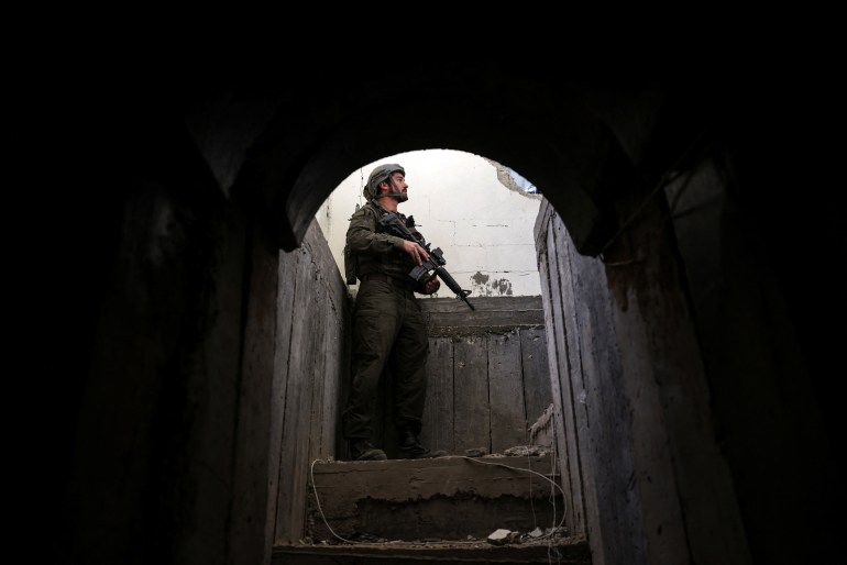 tunnel-4-1706803263 An Israeli soldier stands at the entrance to a tunnel as he operates amid the ongoing conflict between Israel and the Palestinian Islamist group Hamas, in Gaza, January 8, 2024. REUTERS/Ronen Zvulun EDITOR'S NOTE: REUTERS PHOTOGRAPHS WERE REVIEWED BY THE IDF AS PART OF THE CONDITIONS OF THE EMBED. TWO PHOTOS WERE REMOVED BY REUTERS UPON IDF REQUEST, CITING SECURITY CONCERNS. ONE SHOWED A TANK MARKING AND THE OTHER EXPOSED A LOCATION OF TROOPS