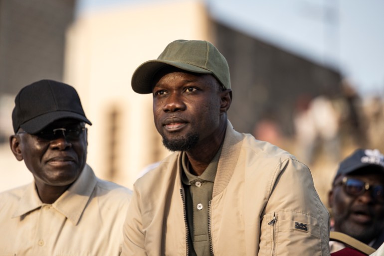 33bc4qe-highres Opposition leader Ousmane Sonko (C) looks on during an opposition meeting two days before his trial, in Dakar on March 14, 2023. - Thousands of supporters of Senegalese opposition leader Ousmane Sonko rallied in Dakar on March 14, 2023, the first of several days of protests as the country prepares for elections in less than a year. Sonko is expected in court TMarch 16, 2023 after being sued by Tourism Minister Mame Mbaye Niang for "defamation, insult and forgery". (Photo by JOHN WESSELS / AFP)