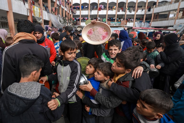 fdsf5-1708929475-1 Displaced Palestinian children gather to receive food at a government school in Rafah in the southern Gaza Strip on February 19, 2024, amid the ongoing battles between Israel and the militant group Hamas. (Photo by MOHAMMED ABED / AFP)