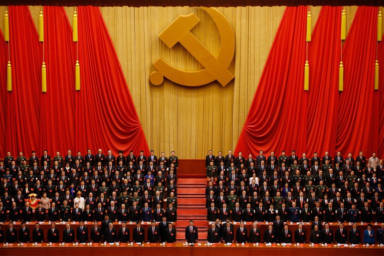FILE - Chinese President Xi Jinping, front row center, stands with his cadres during the Communist song at the closing ceremony for the 19th Party Congress at the Great Hall of the People in Beijing on Oct. 24, 2017. China's long-ruling Communist Party on Tuesday, Aug. 30, 2022, set October 16 for its 20th party congress, at which leader Xi is expected to be given a third five-year term. (AP Photo/Ng Han Guan, File)
