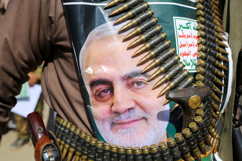 rts2xct7 A supporter of the Houthis has a poster attached to his waist of Iranian Major-General Qassem Soleimani, head of the elite Quds Force, who was killed in an air strike at Baghdad airport, during a rally to denounce the U.S. killing, in Saada