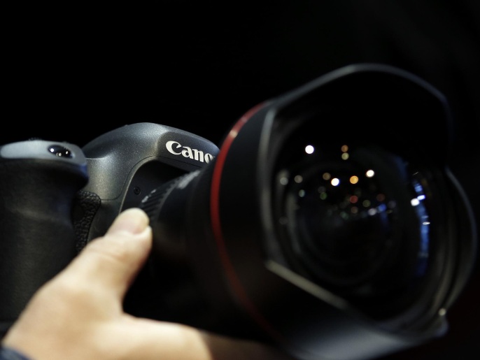c087b8ce-2131-4787-987d-1124e0010ac3 An attendee tries out a Canon Inc. EOS-5Ds digital single lens reflex (DSLR) camera mounted with an EF 11-24mm f/4L USM ultra-wide zoom lens at the CP+ Camera and Photo Imaging Show in Yokohama, Kanagawa Prefecture, Japan, on Thursday, Feb. 12, 2015. The largest camera and photo imaging show in Japan, hosted by the Camera & Imaging Products Association, runs through Feb. 15.