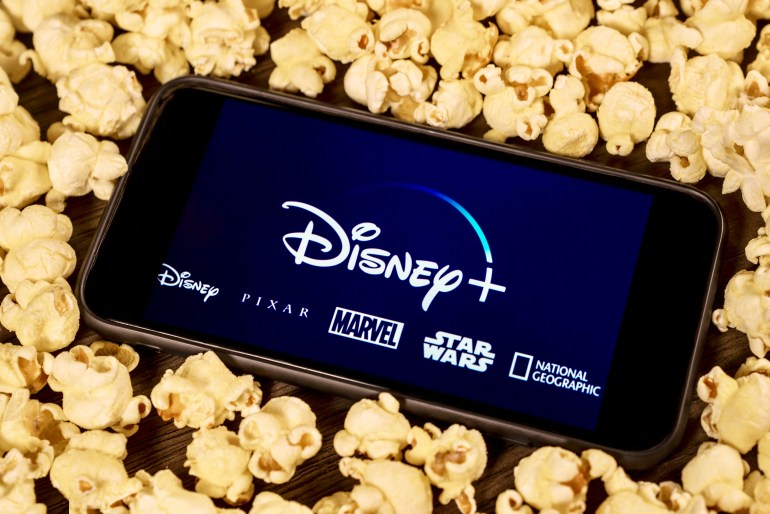 dfdfdf6-1714140609 Grand Prairie, TX/USA - Aug 2019: Disney Plus on smartphone with popcorn. Dinsey+ is a new streaming subscription service that will feature Marvel, Pixar, Star Wars, and National Geographic content