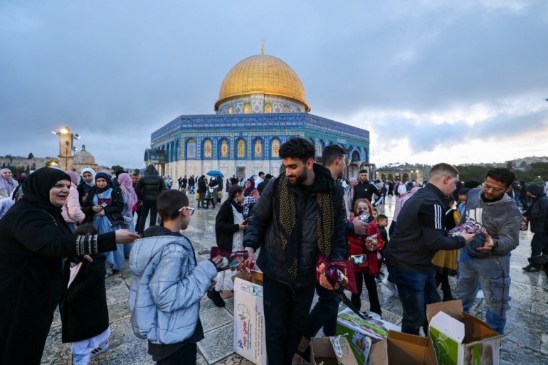 dsf1-1712733736 Volunteers distribute dates as Muslims arrive to offer special morning prayers to start the Eid al-Fitr festival, which marks the end of the holy fasting month of Ramadan, at the Al-Aqsa Mosque compound in Jerusalem on April 10, 2024. (Photo by AHMAD GHARABLI / AFP)