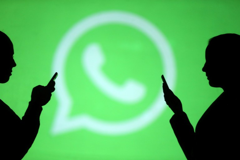 99-1697962121 Silhouettes of mobile users are seen next to a screen projection of Whatsapp logo in this picture illustration taken March 28, 2018. REUTERS/Dado Ruvic/Illustration