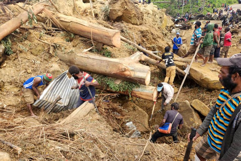 This handout photo taken and received on May 27, 2024 from the International Organization for Migration shows locals digging at the site of a landslide at Mulitaka village in the region of Maip Mulitaka, in Enga Province, Papua New Guinea. - More than 2,000 people have been buried in a Papua New Guinea landslide that destroyed a remote highland village, the government warned May 27 as it called for international help in the rescue effort. (Photo by Mohamud Omer / International Organization for Migration / AFP) / NO USE AFTER JUNE 6, 2024 08:46:45 GMT - RESTRICTED TO EDITORIAL USE - MANDATORY CREDIT "AFP PHOTO / INTERNATIONAL ORGANIZATION FOR MIGRATION / MOHAMUD OMER - NO MARKETING NO ADVERTISING CAMPAIGNS - DISTRIBUTED AS A SERVICE TO CLIENTS - NO ARCHIVE /