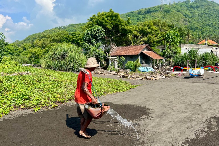 d9a2d9a2d9a2d9a22-1715518706 عامل الملح نيومان وارتا يصب مياه البحر على شاطئ كوسامبا المظلم. وهو أحد آخر ممثلي هذه المهنة في جزيرة بالي الإندونيسية لقضاء العطلات. يمكن للسياح شراء الملح المستخرج بشكل طبيعي والغني بالمعادن مباشرة من الموقع. صور: Carola Frentzen/dpa Credit: Carola Frentzen/dpa