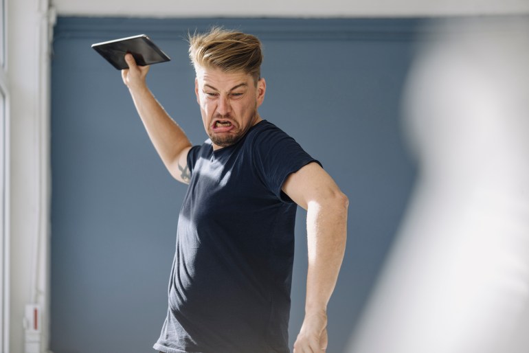 gettyimages-1227561441-1715173153 Angry man throwing tablet away