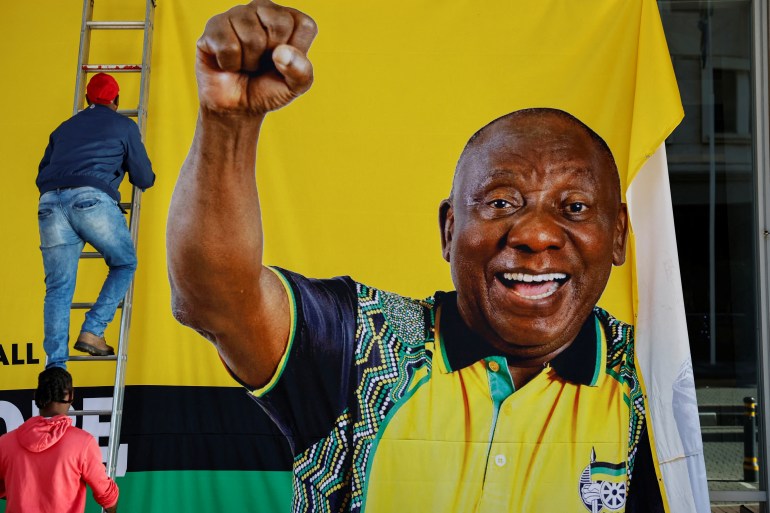 A worker removes a campaign banner of South African president Cyril Ramaphosa after an African National Congress (ANC) event ahead of the upcoming elections in Sandton, Johannesburg, South Africa May 25, 2024. REUTERS/James Oatway