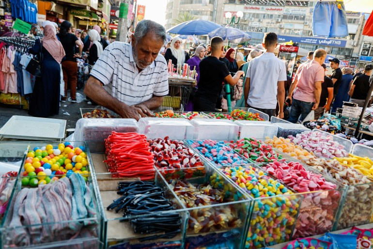 2023-06-27t08ps-1718271677 A Palestinian street vendor sells candies at a market before Eid al-Adha, in Nablus in the Israeli-occupied West Bank, June 26, 2023. REUTERS/Raneen Sawafta