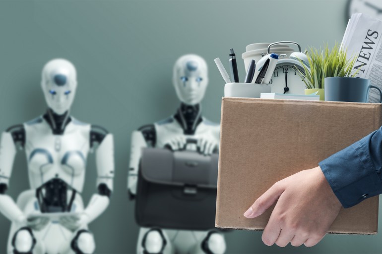 468888-1-1683715880 Fired office worker holding a box with her belongings and leaving the office, humanoid AI robots waiting for a job interview i: the impact of artificial intelligence and robotics on unemployment; Shutterstock ID 2270550899; purchase_order: aljazeera ; job: ; client: ; other: