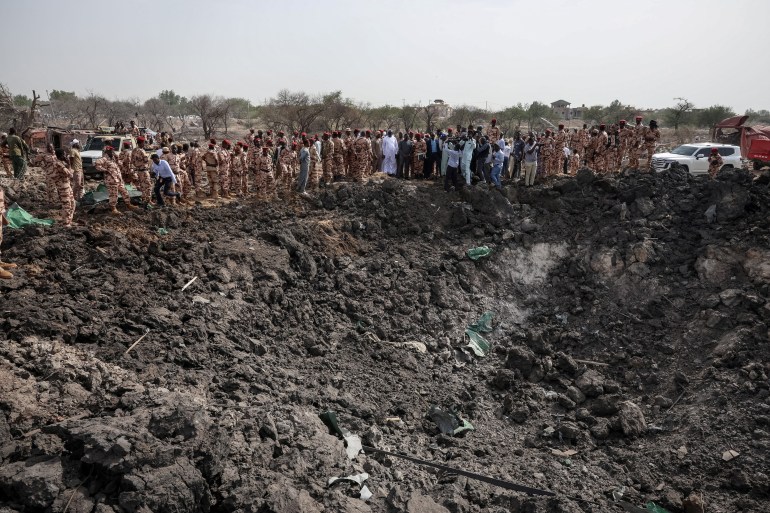Members of the Chadian security forces stand at the scene of the fire at a ammunition depot in NDjamena on June 19, 2024. - A deadly fire erupted late on June 18, 2024 at a huge military ammunition depot in Chad's capital N'Djamena, causing weapons to fire into the air, the government and witnesses said. (Photo by Joris Bolomey / AFP)
