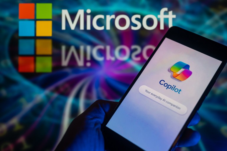 gettyimages-1889116289-1704194140 The Microsoft Copilot app is being displayed on a smartphone, with the Microsoft logo visible in the background, in this photo illustration taken in Brussels, Belgium, on December 30, 2023. (Photo by Jonathan Raa/NurPhoto via Getty Images)