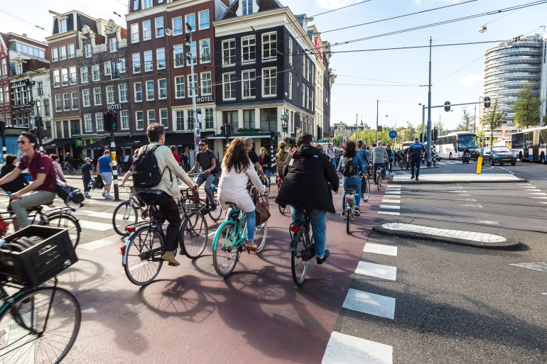 shutterstock_559798888-1717414323 AMSTERDAM, THE NETHERLANDS - JUNE 16, 2016: People riding bicycles in historical part of Amsterdam in a beautiful summer day, The Netherlands on June 16, 2016