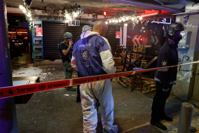 Police and forensics expert arrive at the scene in the aftermath of a shooting attack in Dizengoff Street in the centre of Israel's Mediterranean coastal city of Tel Aviv on April 7, 2022. - At least five people were wounded, three severely, during an attack in Tel Aviv on April 7. Eli Bin, head of the Magen David Adom emergency responders, told public TV broadcaster Kan that one of the wounded was "in a critical state," after the latest incident in a surge of violence occurring in Israel and the West Bank. (Photo by JACK GUEZ / AFP)