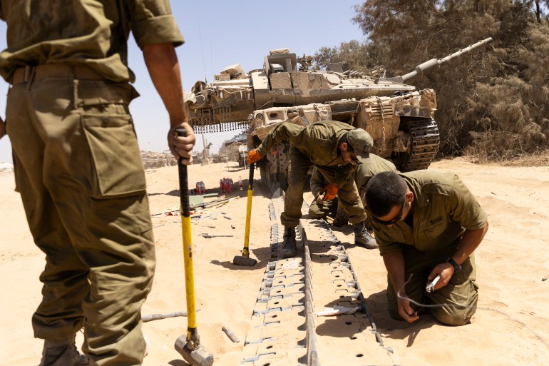 جنود إسرائيليون يصلحون دبابة في غزة