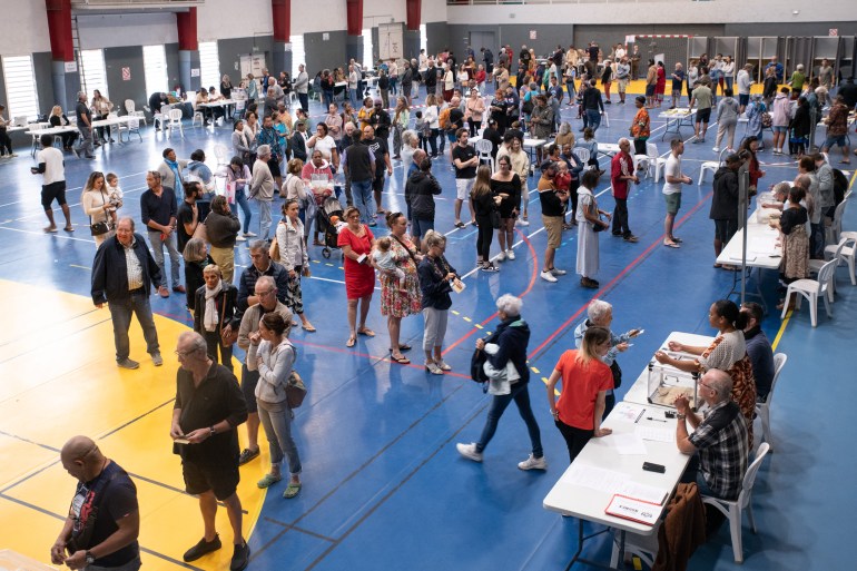 d8b4d8a8d8ad-d985d987d8b1d8ab2-1720384983 Voters queue at the Anse Vata sports hall, which hosts ten polling stations, in Noumea, in the French Pacific territory of New Caledonia, during the second round of France's legislative elections on July 7, 2024. - To ensure optimum security conditions for the second round of the legislative elections, the 56 polling stations in the commune of Noumea were grouped together in seven locations, covering all sectors of the city. France votes in legislative elections on July 7 that will be decisive in determining its political future and could see the far right become the largest party in parliament for the first time. (Photo by Delphine MAYEUR / AFP)