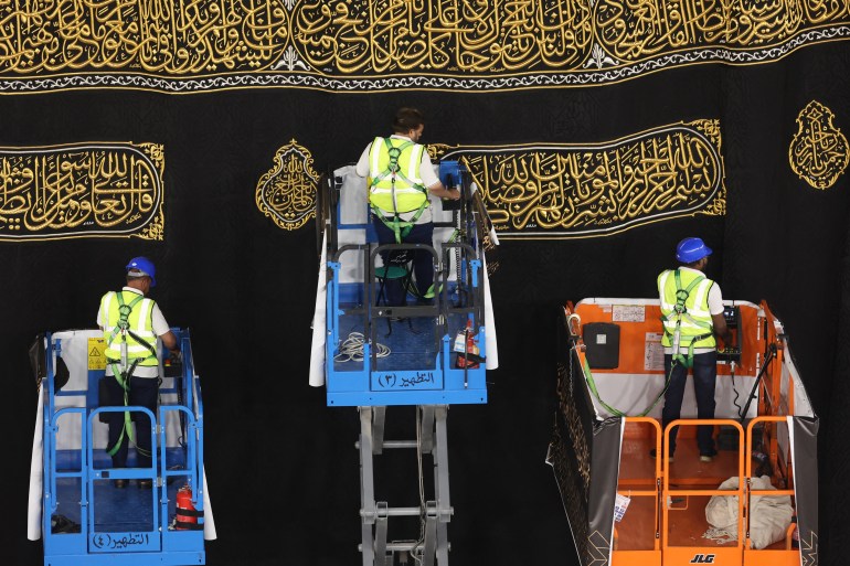 d98ad8a8d9877-1720349810 Saudi workers adjust the new Kiswa, the protective cover that engulfs the Kaaba which is made from black silk and gold thread and is embroidered with Koran verses, in Saudi Arabia's holy city of Mecca, on July 6, 2024. (Photo by Abdel Ghani BASHIR / AFP)