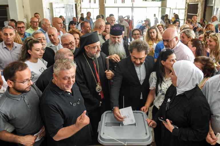 Christian clergymen stand around a voter casting a ballot into a box at a polling station during the 2024 Syrian parliamentary elections in Syria's northern city of Aleppo on July 15, 2024. Syrians in government-held areas were voting on July 15 in their fourth parliamentary election since civil war erupted in 2011, a poll expected to keep President Bashar al-Assad's ruling Baath party in power. (Photo by AFP)