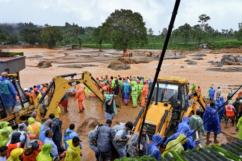 india1-1722350550 Relief personnel conduct a search and rescue operation at a site following landslides in Wayanad on July 30, 2024. - Landslides in India triggered by pounding monsoon rains struck tea plantations and killed at least 93 people on July 30, with at least 250 others rescued from mud and debris, officials said. (Photo by R. J. Mathew / AFP)
