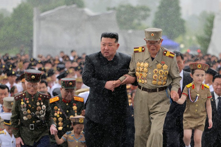 This picture taken on July 26, 2024 and released from North Korea's official Korean Central News Agency (KCNA) via KNS on July 27, 2024 shows North Korea's leader Kim Jong Un (C) with a war veteran as he visits the graves of soldiers to mark the occasion of the 71st anniversary of the end of the Korean War, in Pyongyang. (Photo by KCNA VIA KNS / AFP) / South Korea OUT / SOUTH KOREA OUT / REPUBLIC OF KOREA OUT ---EDITORS NOTE--- RESTRICTED TO EDITORIAL USE - MANDATORY CREDIT "AFP PHOTO/KCNA VIA KNS" - NO MARKETING NO ADVERTISING CAMPAIGNS - DISTRIBUTED AS A SERVICE TO CLIENTS / THIS PICTURE WAS MADE AVAILABLE BY A THIRD PARTY. AFP CAN NOT INDEPENDENTLY VERIFY THE AUTHENTICITY, LOCATION, DATE AND CONTENT OF THIS IMAGE --- /
