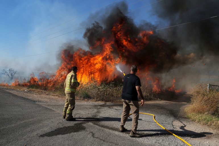 An Israeli firefighter and a man from the immediate responders team work to take control over a fire on the Israeli side of the Israel-Lebanon border amid ongoing cross-border hostilities between Hezbollah and Israeli forces, July 1, 2024. REUTERS/Ayal Margolin ISRAEL OUT. NO COMMERCIAL OR EDITORIAL SALES IN ISRAEL