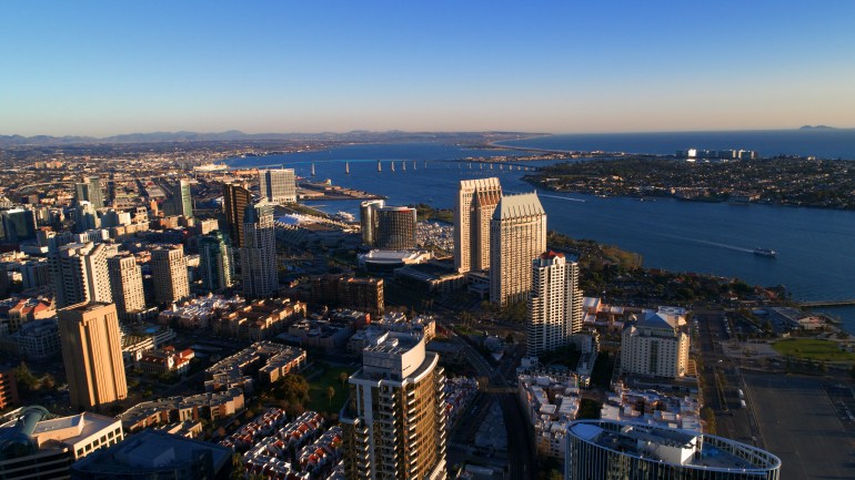 shutterstock_1033823368-1720004433 The Coronado island bridge, silver strand, downtown San Diego, harbor, and a distant Mexico island in the Pacific Ocean.