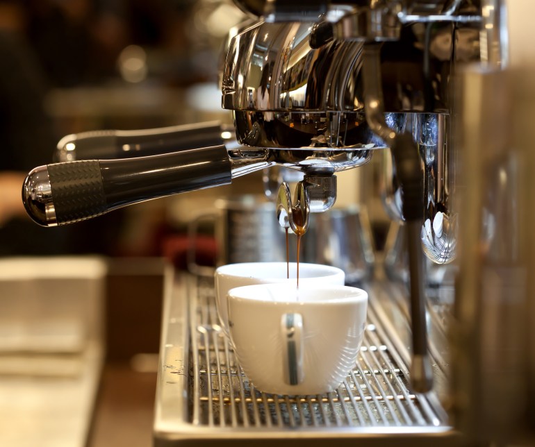 shutterstock_99664388-1721814980 prepares espresso in his coffee shop; close-up