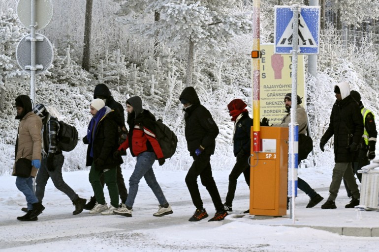 Refugees walk at the international border crossing at Salla, northern Finland, November 22, 2023. Lehtikuva/Jussi Nukari via REUTERS ATTENTION EDITORS - THIS IMAGE WAS PROVIDED BY A THIRD PARTY. NO THIRD PARTY SALES. NOT FOR USE BY REUTERS THIRD PARTY DISTRIBUTORS. FINLAND OUT. NO COMMERCIAL OR EDITORIAL SALES IN FINLAND. REFILE - CORRECTING DATE