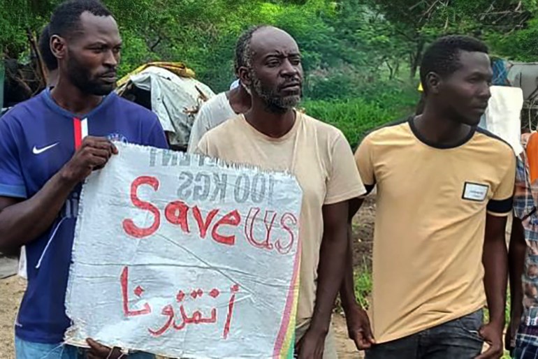 Sudanese refugees hold a sign that reads ‘save us’ as they protest poor conditions and the lack of protection in Ethiopia [Courtesy of Montasser/Al Jazeera]