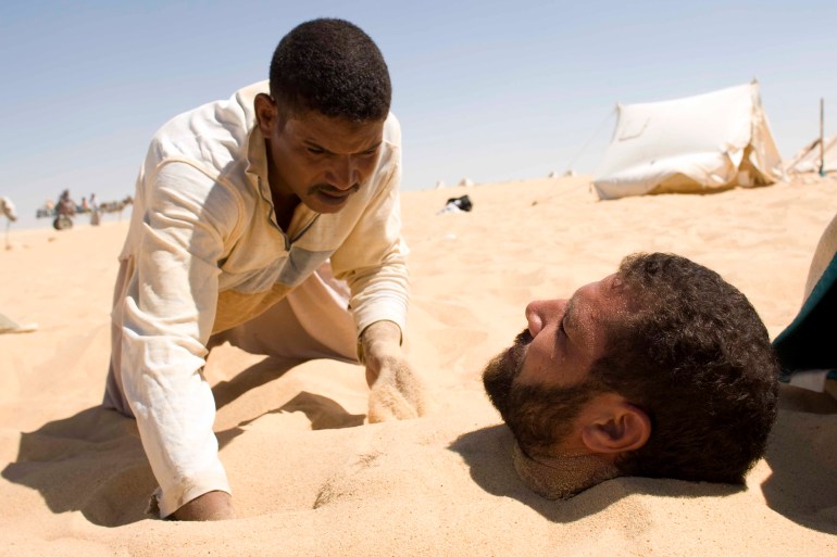 Mohmmed Emad, 41, lies buried neck-deep in the sand in the El Dakrror mountain area at Siwa Oasis, 700 km northwest of Cairo and 55 km to the Libyan border, August 12, 2008. The people in Siwa believe that being buried in the sand during the hottest time of the day is a therapeutic treatment which can cure rheumatism, joint pain and sexual impotency. REUTERS/Nasser Nuri (EGYPT)