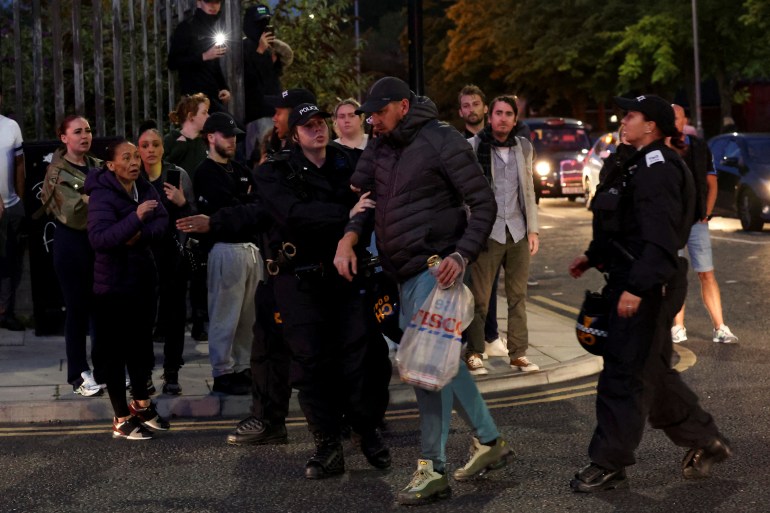 d8b1d8b1d8b1-2-1723101553 A police officer holds a man after he argues with people on the sidewalk as people gather against an anti-immigration protest, in Liverpool, Britain, August 7, 2024. REUTERS/Manon Cruz