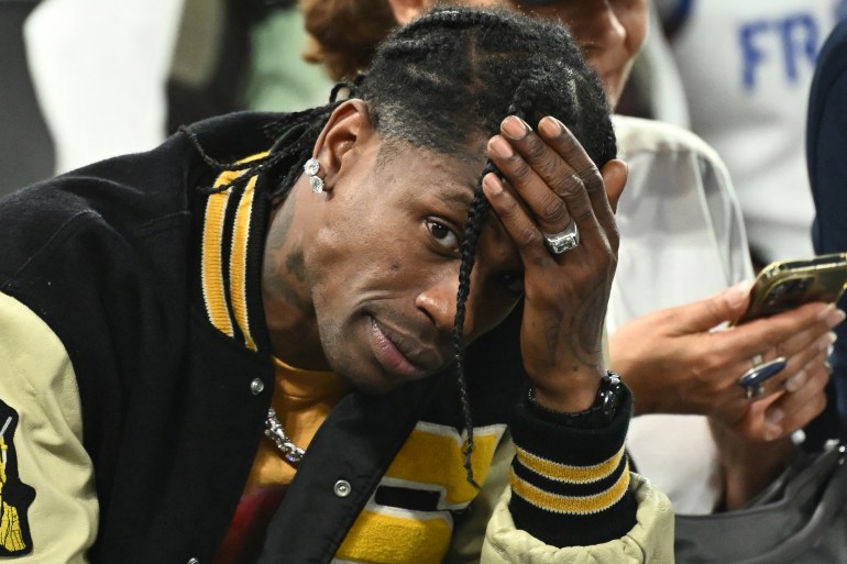 US rap artist Travis Scott gestures as he attends the men's semi-final basketball match between France and Germany during the Paris 2024 Olympic Games at The Bercy Arena in Paris on August 8, 2024. - Paris prosecutor's office announced on August 9, 2024, that US rap artist Travis Scott has been arrested in Paris after a fight at The Georges V Hotel in the French capital. (Photo by Aris MESSINIS / AFP)