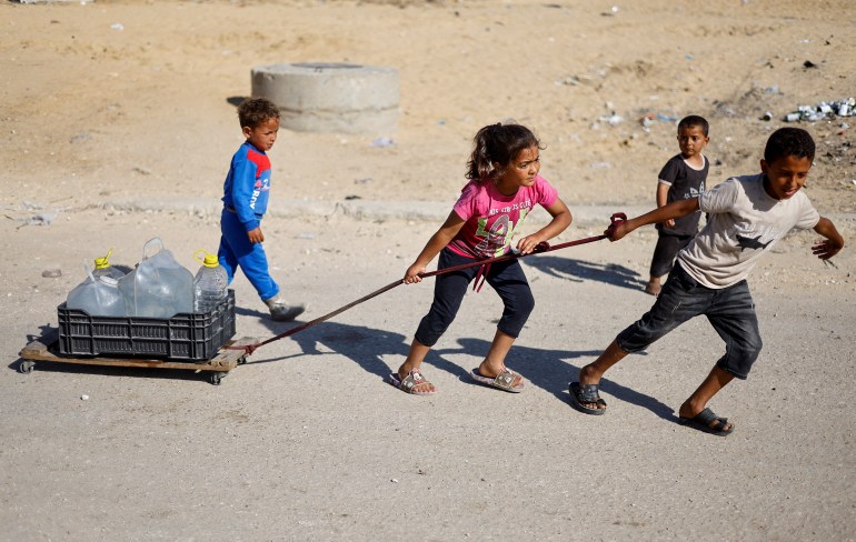 Palestinian children pull water containers as people flee Rafah after Israeli forces launched a ground and air operation in the eastern part of the southern Gaza city, amid the ongoing conflict between Israel and Hamas, in the southern Gaza Strip May 9, 2024. REUTERS/Mohammed Salem TPX IMAGES OF THE DAY