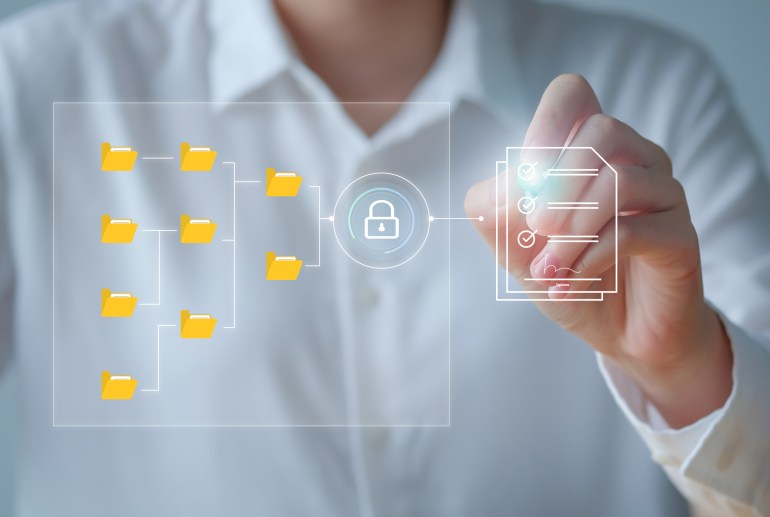 gettyimages-1419265024-1723724026 Document Management System - DMS , online documentation database and process to efficiently manage files. Data storage. Hand searching folder and document pass through cyber security غيتي