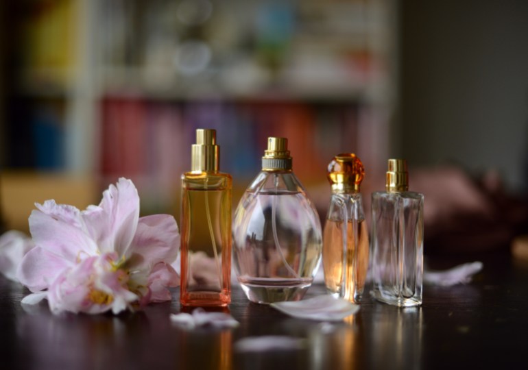 gettyimages-974936508-1723986648 Perfume bottles in summery colors and peony petals