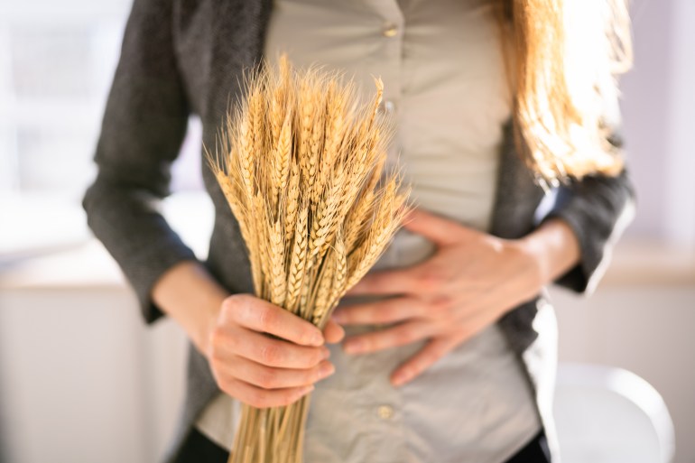 shutterstock_2129755706 Celiac Disease And Gluten Intolerance. Women Holding Spikelet Of Wheat