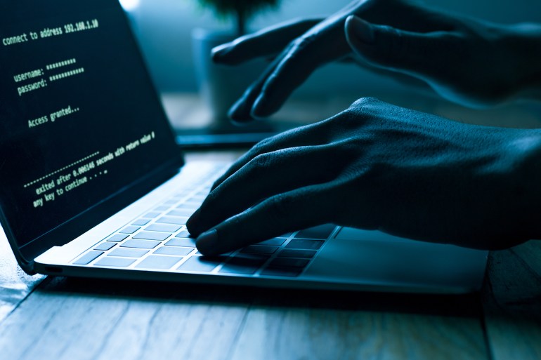 ss1053921923 A computer programmer or hacker prints a code on a laptop keyboard to break into a secret organization system.