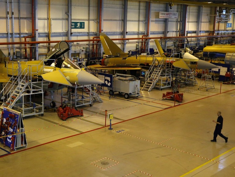 A worker crosses the floor of the Eurofighter Typhoon production line at BAE systems Warton plant near Preston, northern England September 7, 2012. REUTERS/Phil Noble (BRITAIN - Tags: BUSINESS MILITARY)