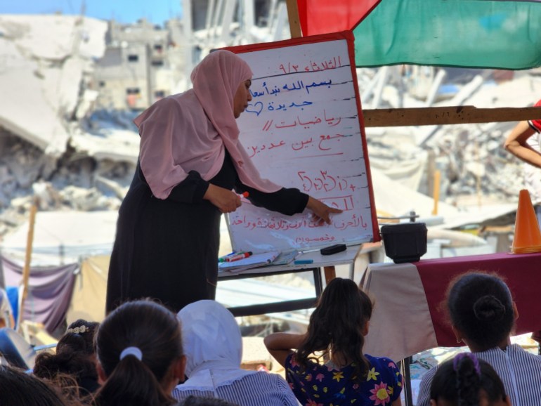 KHAN YUNIS, GAZA - SEPTEMBER 03: Teacher Alaa Abu Mustafa gives lessons at a tent school built over her house which was destroyed after Israeli attacks in Khan Yunis, Gaza on September 03, 2024. Despite the limited and difficult conditions, teacher Alaa strives to ensure that primary school students are not deprived of education. (Photo by Hani Alshaer/Anadolu via Getty Images)