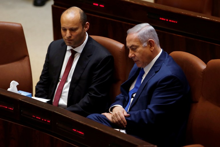 Israeli Prime Minister Benjamin Netanyahu sits next to Israeli Education Minister Naftali Bennett during a session of the plenum of the Knesset, the Israeli Parliament, in Jerusalem
