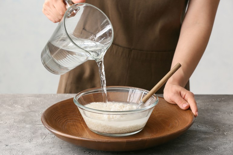 shutterstock_2065937777-1727013763 Woman preparing rice water on table; Shutterstock ID 2065937777; purchase_order: aj net; job: ; client: ; other: