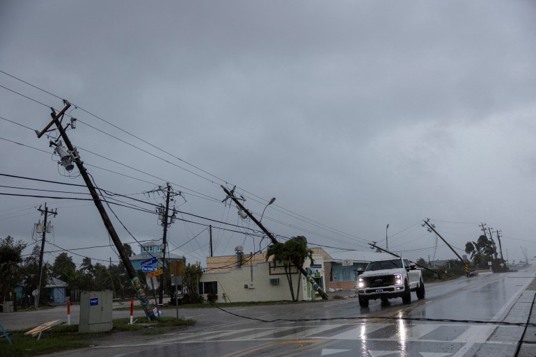 2024-10-02on-1728560468 A motorist drives past broken utility poles downed by strong wind gusts as Hurricane Milton approaches Fort Myers, Florida, U.S. October 9, 2024. REUTERS/Ricardo Arduengo