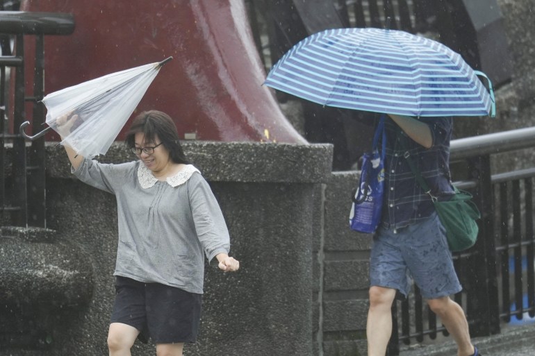 2024-10-31t064an-1730379154 People hold umbrellas as Typhoon Kong-rey approaches in Keelung, Taiwan October 31, 2024. REUTERS/Walid Berrazeg