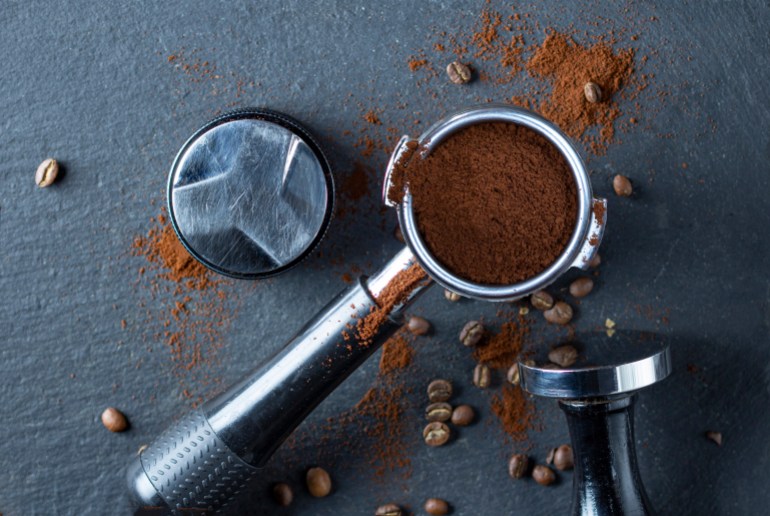 Portafilter with coffee and temper on table