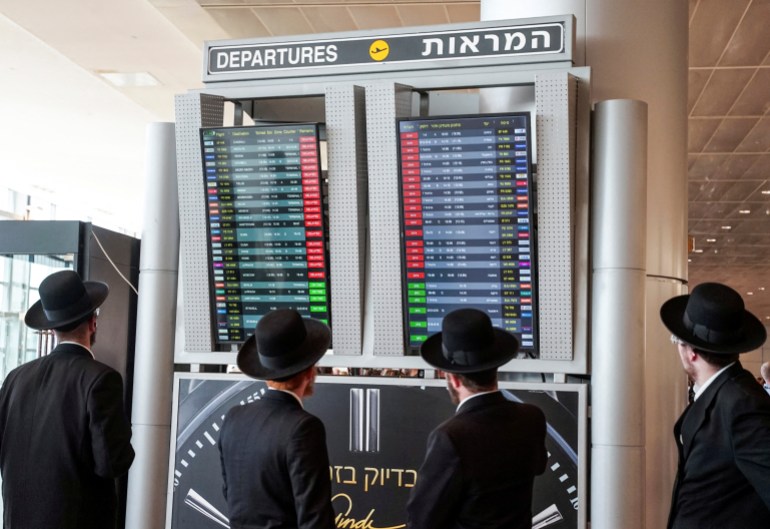 d8a8d8a8-2-1724669590 Travellers look at a monitor displaying delayed flights after take-offs were suspended as part of nationwide protests against the government's judicial overhaul plan, according to an airport spokesperson, at Ben Gurion International Airport in Lod, Israel March 27, 2023. REUTERS/Itai Ron